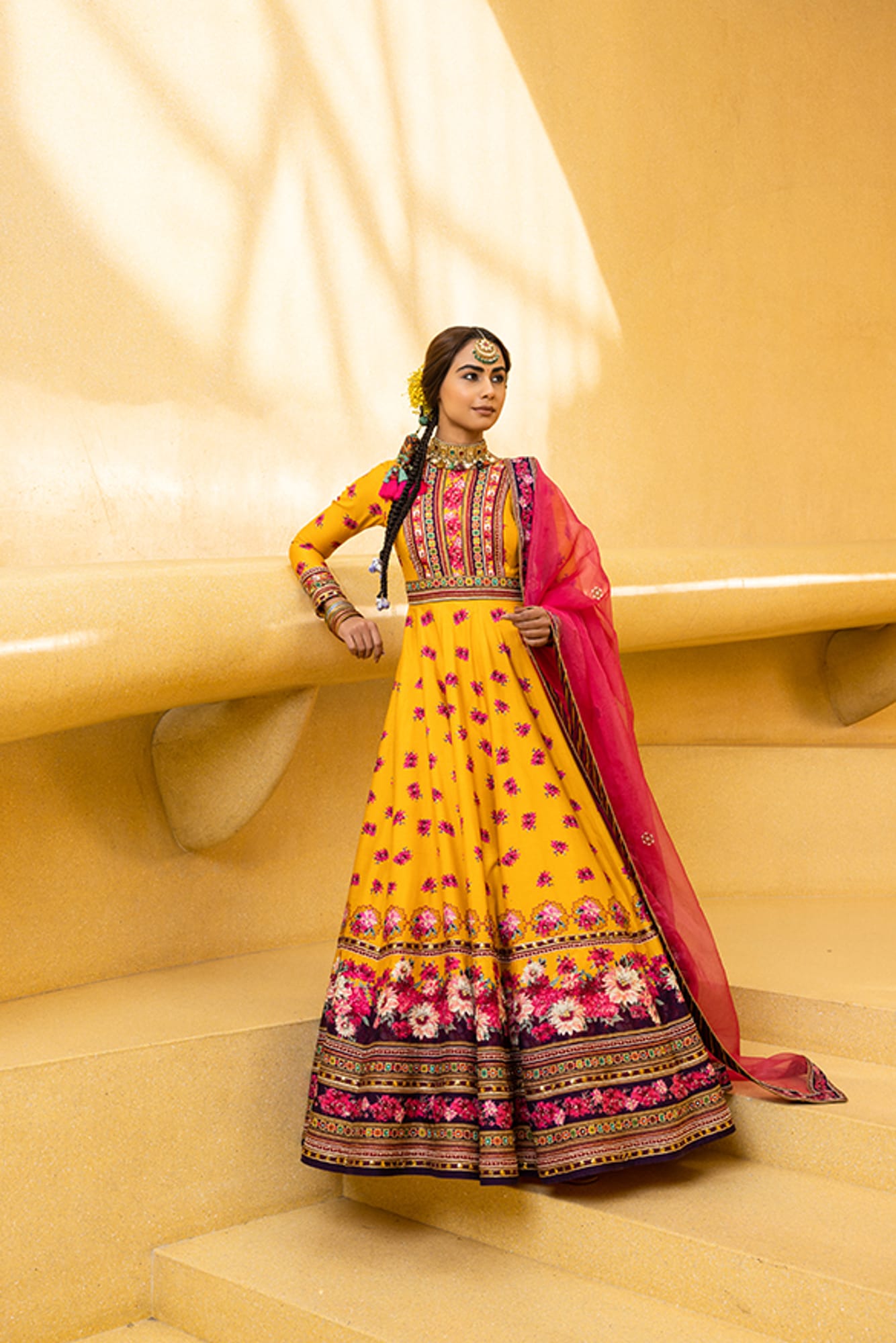 Women Wearing Yellow Anarkali Set With Pink Dupatta.